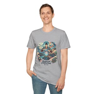 Può includere: T-shirt grigio chiaro con una grafica colorata che presenta le parole "Quantum Computing" e caratteri giapponesi. La grafica raffigura una persona in abito tradizionale, circondata da motivi vorticosi e forme geometriche.