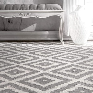 May include: A rectangular area rug featuring a repeating geometric diamond pattern in shades of grey and white. The rug covers the floor space, displaying a consistent, symmetrical motif across its entire visible surface area.