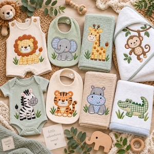 Op de afbeelding: Een verzameling babyartikelen waaronder een crèmekleurige romper met een leeuw, een groen slabbetje met een olifant, een groene handdoek met een giraf, een witte handdoek met capuchon met een aap, een groen rompertje met een zebra, een crèmekleurig slabbetje met een tijger, een crèmekleurige handdoek met een nijlpaard en een witte handdoek met een krokodil.