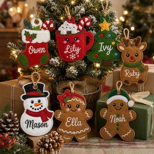 May include: A collection of seven felt Christmas ornaments featuring embroidered designs of a stocking, a mug of cocoa, a tree, a reindeer, a snowman, and two gingerbread figures, each personalized with names including Owen, Lily, Ivy, Ruby, Mason, Ella, and Noah.