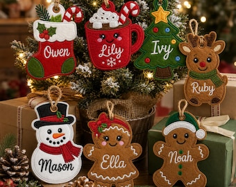 Peut inclure: Un ensemble de sept décorations de Noël en feutrine brodée représentant une chaussette, un mug de chocolat chaud, un sapin, un renne, un bonhomme de neige et deux bonshommes en pain d'épices, personnalisés avec les prénoms Owen, Lily, Ivy, Ruby, Mason, Ella et Noah.