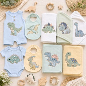 May include: A collection of baby items featuring dinosaur motifs, including a light blue sleeveless romper, a short-sleeve bodysuit, two bibs in light green and yellow, and four folded towels in white, green, and yellow with embroidered dinosaurs.