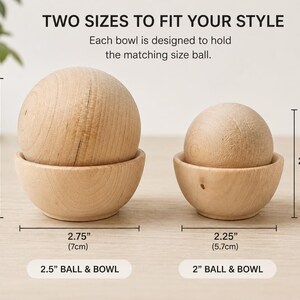 May include: Two light-colored wooden bowls, each holding a matching wooden sphere. Text reads: TWO SIZES TO FIT YOUR STYLE. Each bowl is designed to hold the matching size ball. Measurements show 3.25 inches, 2.75 inches, 2.75 inches, 2.25 inches, 2.5 inch ball & bowl, and 2 inch ball & bowl.