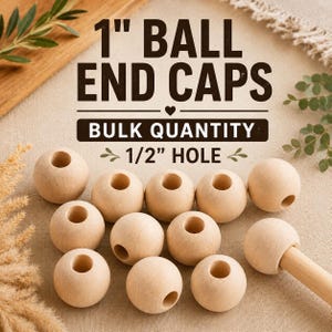 Op de afbeelding: Een verzameling lichtgekleurde houten bolvormige eindkappen, elk met een gat van 1,27 cm. De tekst 1 inch BALL END CAPS, BULK QUANTITY en 1/2 inch HOLE staat boven de houten bollen, waarvan er één aan een houten stok is bevestigd.