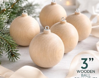 Peut inclure: Un ensemble de quatre boules décoratives en bois clair et lisse, chacune dotée d'un œillet métallique argenté sur le dessus. Le texte 3” WOODEN BALL ORNAMENTS est imprimé en bas à droite, indiquant un diamètre de 7,62 cm.