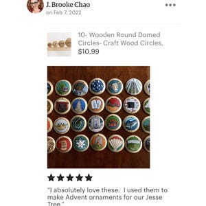 May include: A collection of small, round, domed wooden discs, each featuring a unique hand-painted illustration. The designs include various symbols, animals, and objects, all arranged in a grid pattern. Each disc has a small hole at the top.