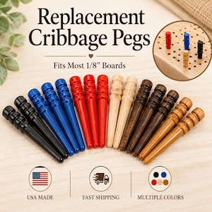 May include: A collection of replacement cribbage pegs in black, blue, red, light wood, dark wood, and tan colors. The pegs feature a tapered design with grooved tops and are compatible with most 1/8 inch boards. Text includes Replacement Cribbage Pegs.