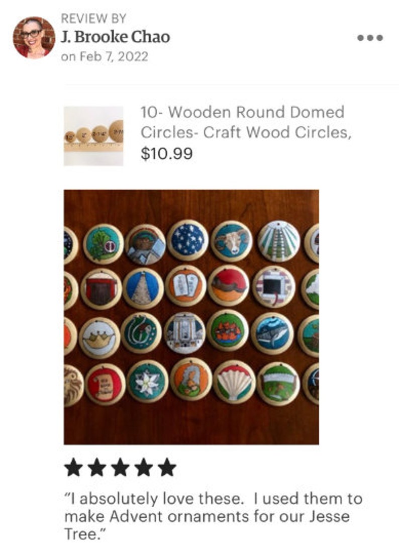 May include: A collection of round wooden ornaments featuring hand-painted illustrations including a crown, a whale, a ram, a shell, a scroll, and various religious symbols. Each circular wooden piece has a small hole at the top for hanging.