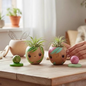Peut inclure: Deux pots en bois avec des visages peints et des accents de feuilles vertes, chacun contenant une petite plante. Un récipient en bois assorti en forme de lapin et deux pièces décoratives en bois sont également sur la table. Les pots mesurent environ 10 cm de diamètre.