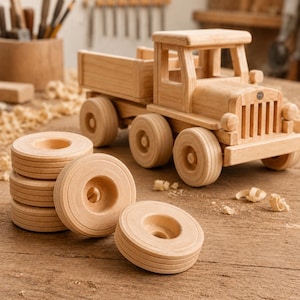 May include: A wooden toy truck with a flatbed and four large wheels. Several spare wooden wheels are stacked in front of the truck. The truck and wheels are made of light-colored wood, with visible wood grain.