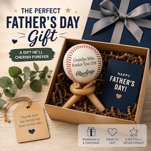 May include: A Father's Day gift set featuring a baseball with personalized text, a navy blue card that says "Happy Father's Day!", and a gift box. The set includes a gift tag that says "Thank you for being my hero every day."