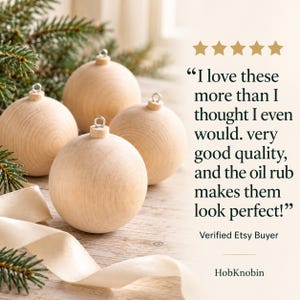 May include: Four round, light-colored wooden ornaments with silver metal hanging loops. The text reads: I love these more than I thought I even would. very good quality, and the oil rub makes them look perfect! Verified Etsy Buyer HobKnobin.