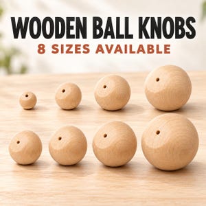 May include: Eight light-colored wooden ball knobs arranged in two rows, each featuring a small centered hole. The text at the top reads WOODEN BALL KNOBS and 8 SIZES AVAILABLE. The spheres vary in diameter, showcasing a natural wood grain finish.