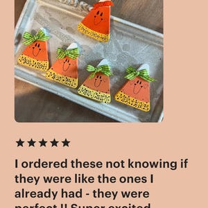May include: Five triangular candy corn ornaments with white tops, orange centers, and yellow bases. Each features a hand-painted smiling face, a green and white gingham bow, and the names Mrs. Wist, Mrs. Jen, Mrs. Cindy, Mrs. Hare, and Happy Halloween.