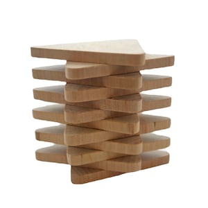 May include: A stack of ten light brown wooden triangles arranged in an alternating pattern. Each piece has a smooth, flat surface and a consistent thickness, creating a vertical tower structure with visible grain patterns on the natural wood material.