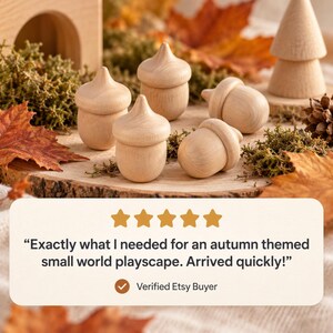 Pu&ograve; includere: Cinque figure in legno di colore chiaro a forma di ghianda con superfici lisce e cappucci arrotondati. Le figure sono disposte in un gruppo. L'immagine include una valutazione a cinque stelle e il testo: Exactly what I needed for an autumn themed small world playscape. Arrived quickly! Verified Etsy Buyer.