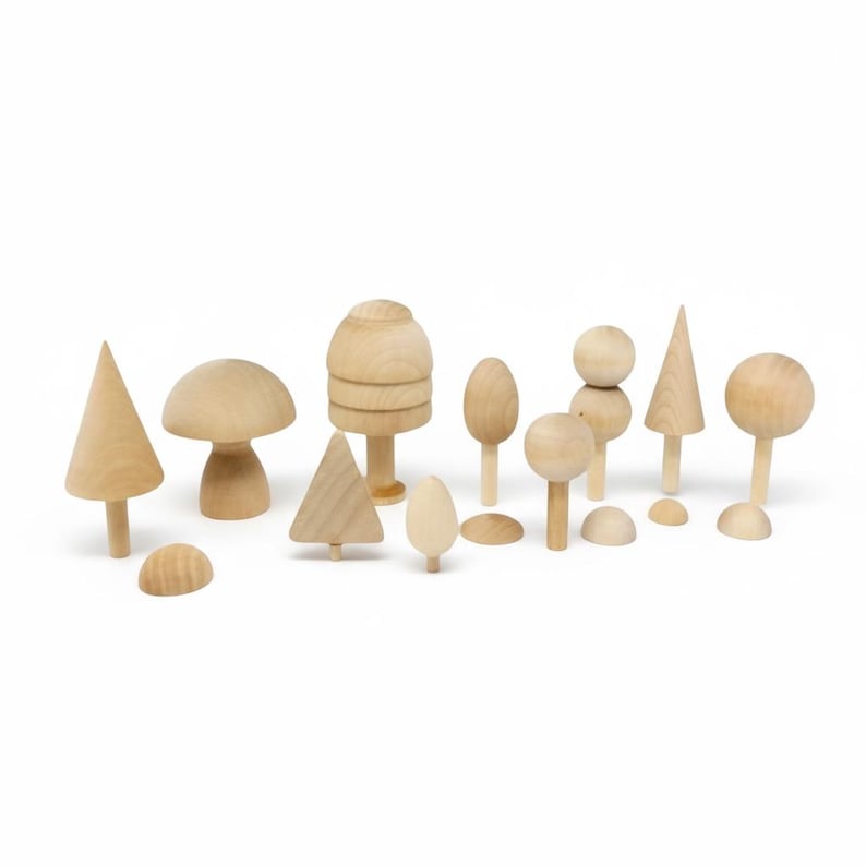 May include: A collection of natural light-colored wooden figures in various shapes including conical trees, rounded mushroom-like forms, spherical tops on stems, and small semi-circular pieces arranged together on a plain white background.