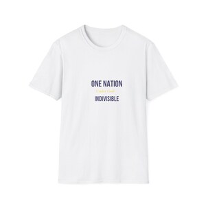 May include: A white short-sleeved t-shirt featuring the text ONE NATION in dark blue, Under God in yellow, and INDIVISIBLE in dark blue centered on the chest. The garment has a crew neckline and a standard fit, presented against a plain white background.