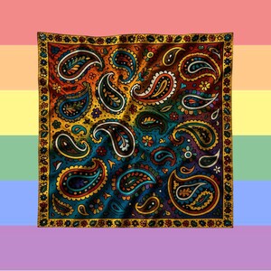 May include: A square scarf featuring a vibrant paisley pattern with multiple colors including orange, yellow, blue, and green. The design includes intricate teardrop shapes and small floral motifs throughout the center, framed by a decorative border.