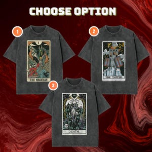 May include: Three charcoal gray t-shirts featuring tarot card graphics. Option 1 shows The Magician with a dragon, option 2 shows The Tower with lightning, and option 3 shows Death with a hooded figure. Each shirt has a crew neck and short sleeves.