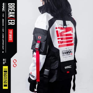 May include: A black, white, and red jacket with multiple pockets and straps. The jacket features the text "BREAKER" and "TYP.WHITE". The design includes a large white panel on the back with red stripes and text. The jacket has a high collar and a modern, technical aesthetic.