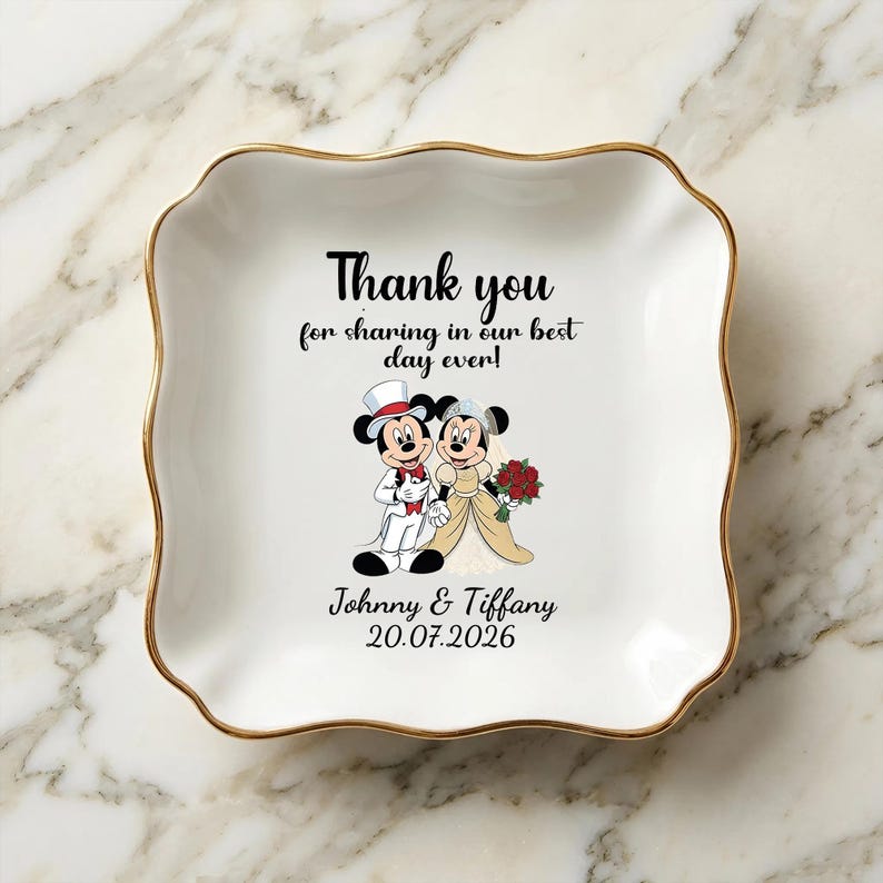 Puede incluir: Un plato de cer&aacute;mica blanco con borde dorado y borde ondulado. El plato presenta una ilustraci&oacute;n de dibujos animados de Mickey y Minnie Mouse con atuendo de boda, con el texto "Thank you for sharing in our best day ever!" y los nombres "Johnny & Tiffany" con la fecha "20.07.2026".