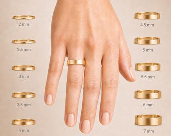 May include: A hand wearing a gold band ring, with several other gold band rings of varying widths displayed around the hand. The rings range in size from 2 mm to 7 mm.