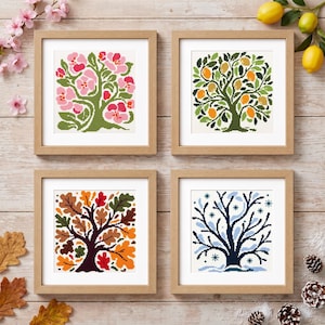 Può includere: Quattro opere d'arte a punto croce con cornice quadrata che raffigurano alberi rappresentanti le quattro stagioni. In alto a sinistra un albero in fiore rosa, in alto a destra un limone, in basso a sinistra una quercia autunnale e in basso a destra un albero invernale.