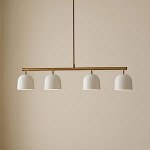 Lampadario lineare in ottone a 4 luci in stile Mid-Century Modern, con cupola color crema, ideale per isola cucina o sala da pranzo.