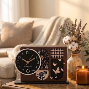 Peut inclure: Une horloge de bureau rectangulaire en bois brun foncé avec un cadran noir circulaire, des aiguilles dorées et le texte UNI-BEAUTY MALL. Le cadre présente des panneaux décoratifs avec des motifs floraux, en losange et de papillons.