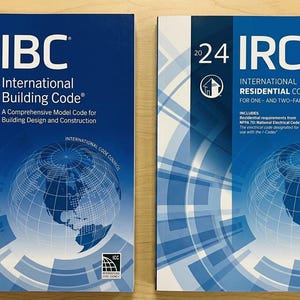 May include: Two 2024 edition reference books with blue covers. The left book is titled 2024 IBC International Building Code, and the right book is titled 2024 IRC International Residential Code for One- and Two-Family Dwellings, both featuring a globe graphic.
