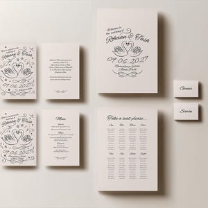 May include: Ivory wedding stationery set with black calligraphy. The set includes invitations, a menu, a seating chart, and place cards. The invitations feature swan illustrations and the wedding date.
