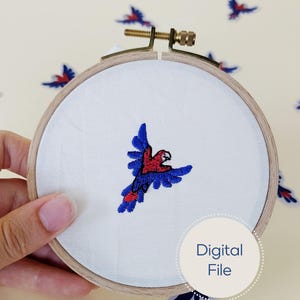 May include: A circular wooden embroidery hoop containing white fabric with a machine-embroidered design of a flying parrot in red and blue thread. A circular white graphic with the text Digital File is overlaid on the bottom right corner.