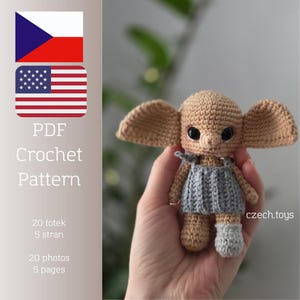 May include: A crocheted doll with large ears, wearing a gray dress and a single gray sock, held in a hand. The doll is tan and brown. The image includes the text "PDF Crochet Pattern" and flags of the Czech Republic and the United States.