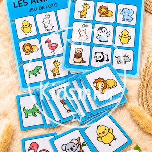 Puede incluir: Un juego de lotería infantil con ilustraciones de animales. Las tarjetas y tableros azules presentan dibujos de animales coloridos, como un león y una jirafa. El texto "LES ANIMAUX JEU DE LOTO" está impreso en los tableros.