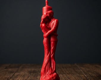 Rött bivaxljus som omfamnar par för kärlek, passion och ritualer