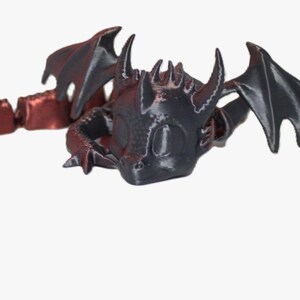Könnte beinhalten: Eine schwarz-rote Drachenfigur mit beweglichen Segmenten. Der Drache hat große Flügel, Hörner und ein detailliertes Gesicht. Die Figur ist auf weißem Hintergrund abgebildet.
