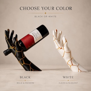 May include: A black and white wine bottle holder in the shape of hands, with gold accents. The black holder cradles a red wine bottle. The text reads "CHOOSE YOUR COLOR" and "BLACK OR WHITE".