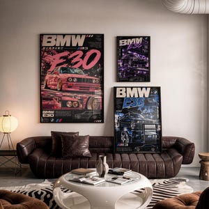 May include: Three framed posters featuring BMW E30 and E36 cars displayed on a wall above a brown leather sofa. The posters include text such as BMW E30 and BMW E36, with graphic illustrations of the vehicles in pink, purple, and blue tones.