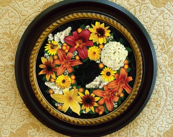 Round framed fine art print of summer flower wreath photo collage. Trompe l'oeil effect. In fine round Victorian-style black and gold frame.