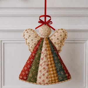 May include: A quilted fabric angel ornament featuring a cream-colored head and wings with a small floral pattern. The dress is composed of vertical panels in red, green, cream, and blue with floral prints and a yellow gingham check, topped with a red ribbon.