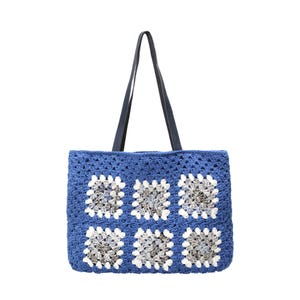 Puede incluir: Un bolso tote rectangular de ganchillo con una base de hilo azul vibrante y seis motivos cuadrados. Cada motivo presenta un centro de hilo gris y blanco matizado rodeado por un borde blanco. El bolso incluye dos asas largas de color azul oscuro.