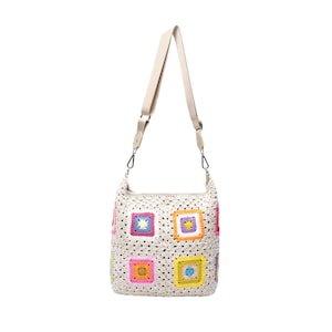 K&ouml;nnte beinhalten: Eine cremefarbene H&auml;keltasche mit beigem Schulterriemen. Die Tasche hat bunte quadratische Muster in Rosa, Gelb, Blau und Gr&uuml;n. Die Tasche hat eine l&auml;ssige, handgemachte &Auml;sthetik.