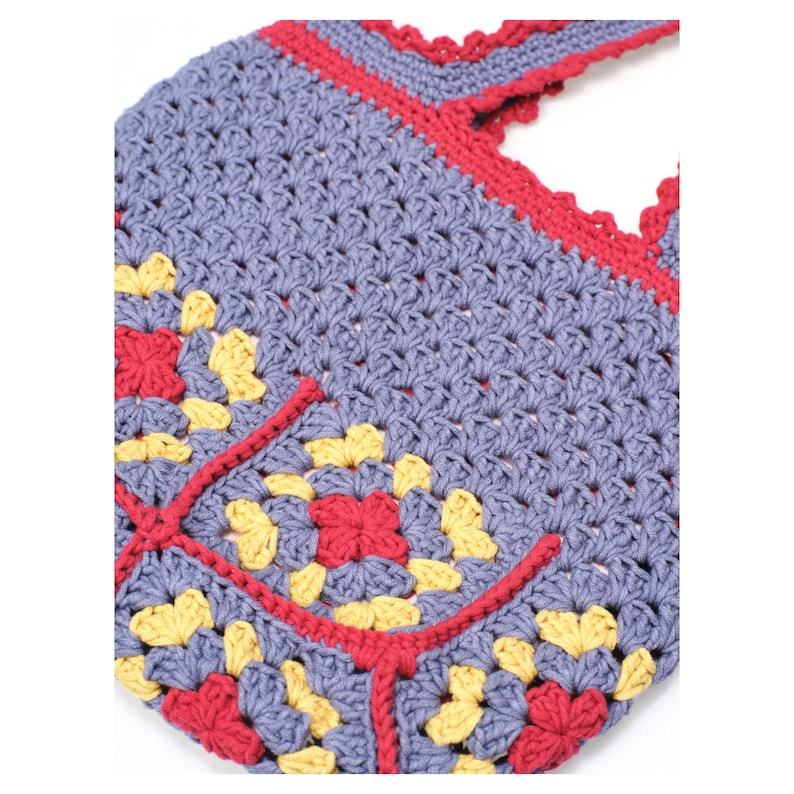 May include: A handmade crochet bag in a granny square design. The bag features a light purple base with red and yellow floral accents. The top and straps are trimmed in red, creating a vibrant contrast.