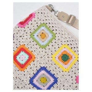K&ouml;nnte beinhalten: Beige H&auml;keltasche mit farbenfrohem Rautenmuster. Die Rauten sind in den Farbt&ouml;nen Rosa, Rot, Orange, Gelb, Gr&uuml;n und Blau gehalten. Die Tasche hat einen verstellbaren beigen Riemen und silberfarbene Hardware.