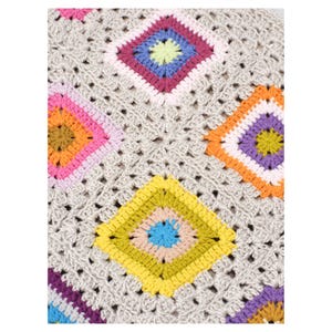 K&ouml;nnte beinhalten: Nahaufnahme einer geh&auml;kelten Decke mit einem sich wiederholenden Muster aus bunten Quadraten. Die Quadrate weisen eine Vielzahl von Farben auf, darunter Rosa, Orange, Gelb, Blau und Lila, vor einem neutralen grauen Hintergrund. Die Decke ist handgefertigt.