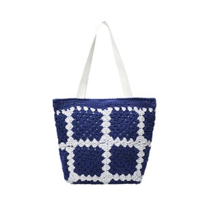 May include: A handmade tote bag with a crocheted design. The bag features a navy blue and white pattern, with white straps. The bag is made of yarn and is suitable for carrying items. The bag is a stylish accessory.