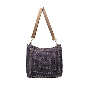 May include: A dark purple crochet shoulder bag featuring a square pattern design with a textured surface. The bag includes a light brown adjustable nylon strap attached with gold-toned metal swivel clasps on both sides of the top opening.