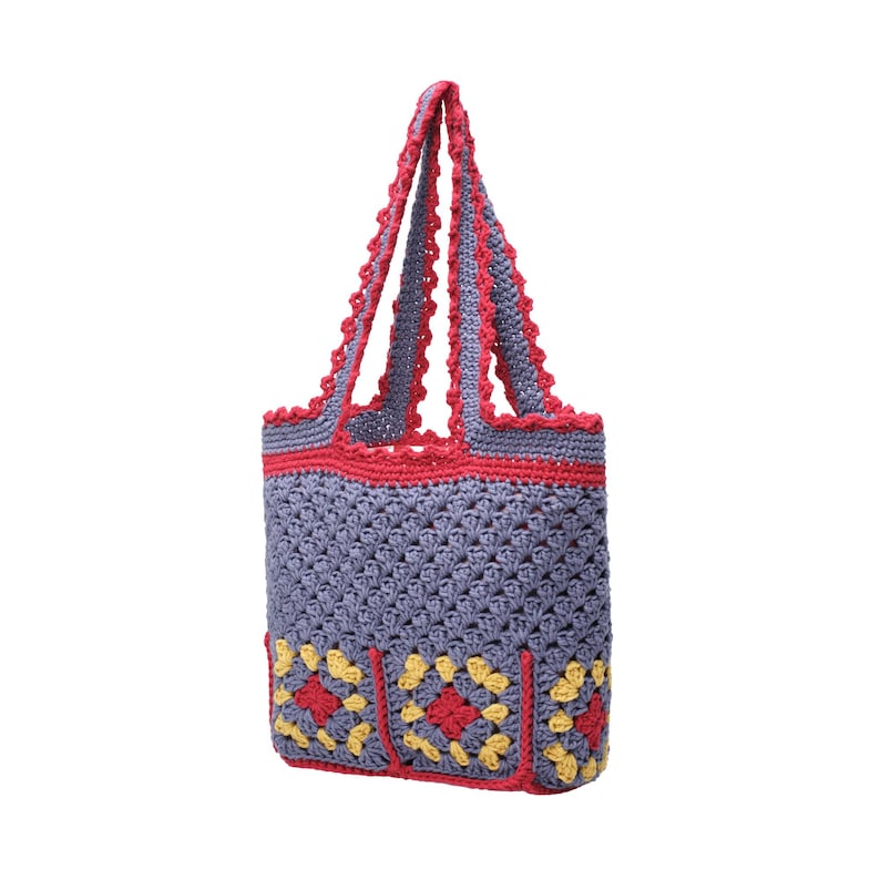 May include: A handmade crochet tote bag in a gray-blue hue, accented with red trim and handles. The bag features a detailed stitch pattern and decorative yellow and red squares at the base. This stylish bag is perfect for carrying groceries or personal items.