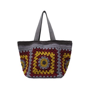 May include: A crochet tote bag featuring a granny square pattern in shades of deep burgundy, mustard yellow, and light gray. The bag has two gray handles and a solid dark gray crocheted top border, constructed with a textured yarn stitch design.